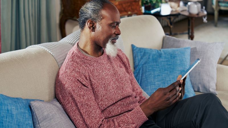 A man sat on the sofa holding his phone