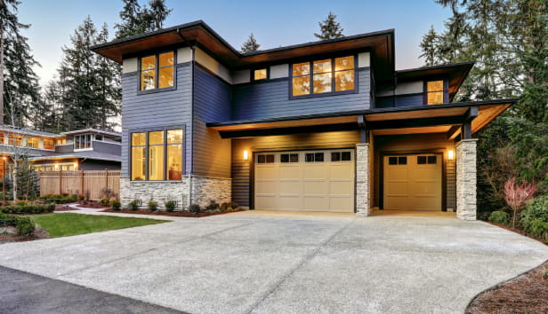 A large and impressive looking home with two garages and a huge driveway
