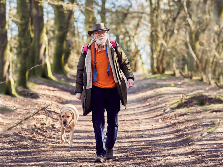 Dr Mike MacLean and his dog taking a walk through the woods || Photo credit: Alun Callender