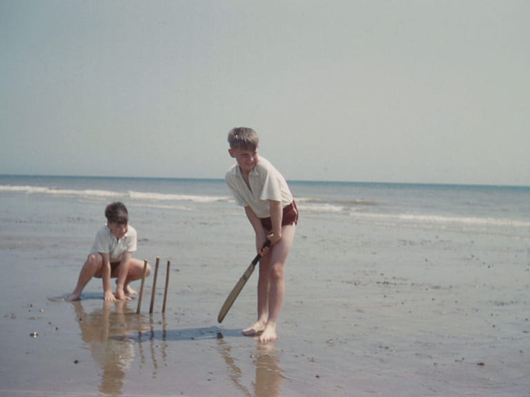 Vintage photo of children playing cricket on the beach