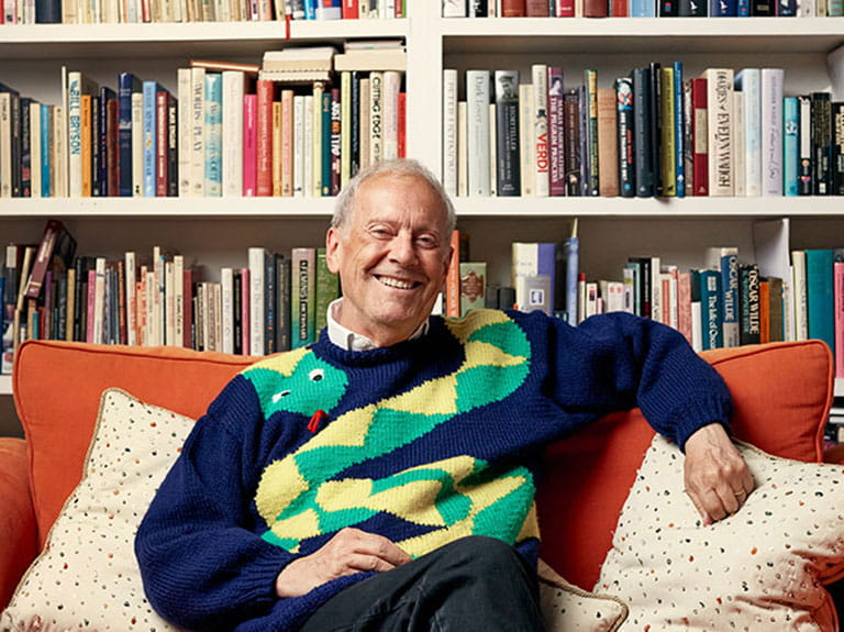 Gyles Brandreth relaxes in front f a packed bookcase | Image Credit: Sophia Spring