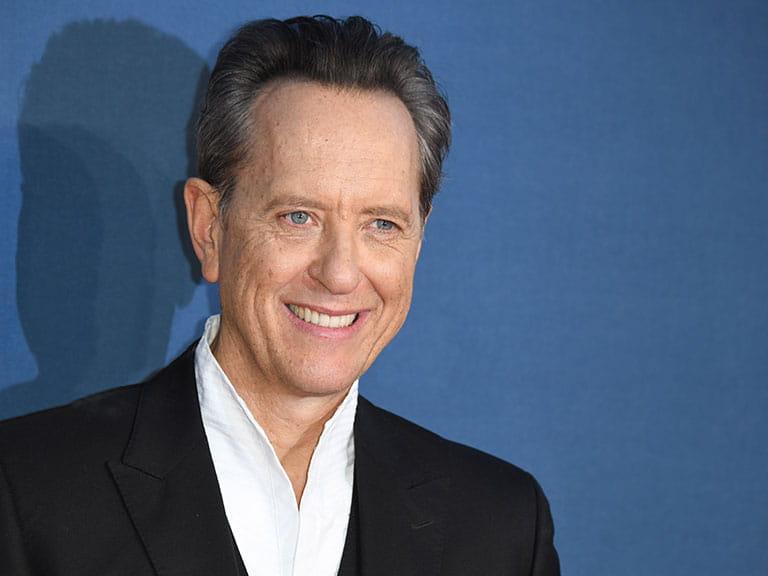 Richard E Grant poses for photos at his film premiere