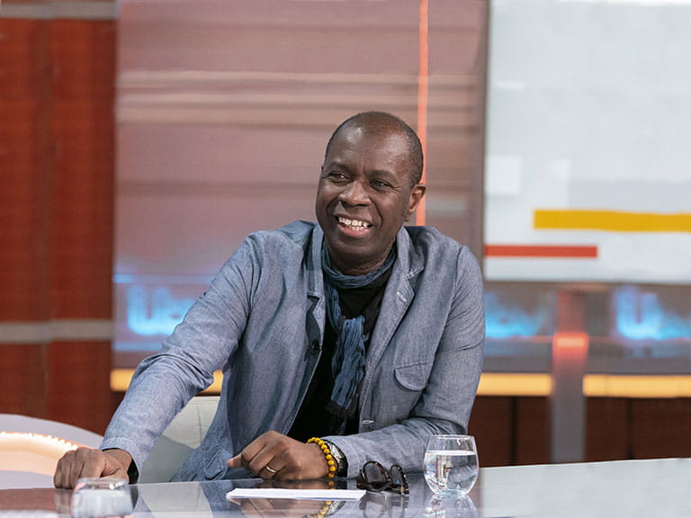 Clive Myrie sits at a desk in the ITV studio Image credit: Ken McKay/​ITV/​Shutterstock