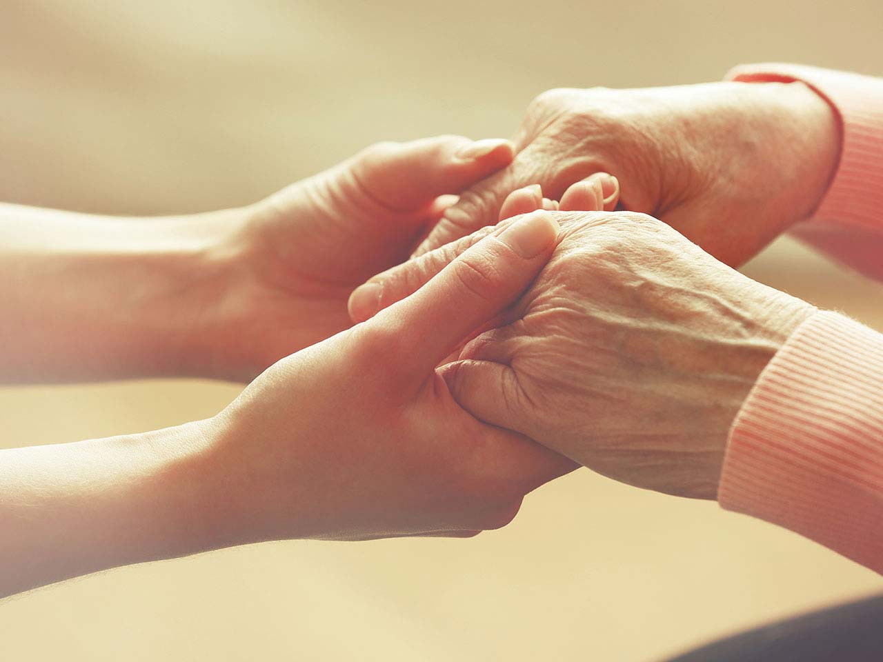 Older lady's arthritic hands being held