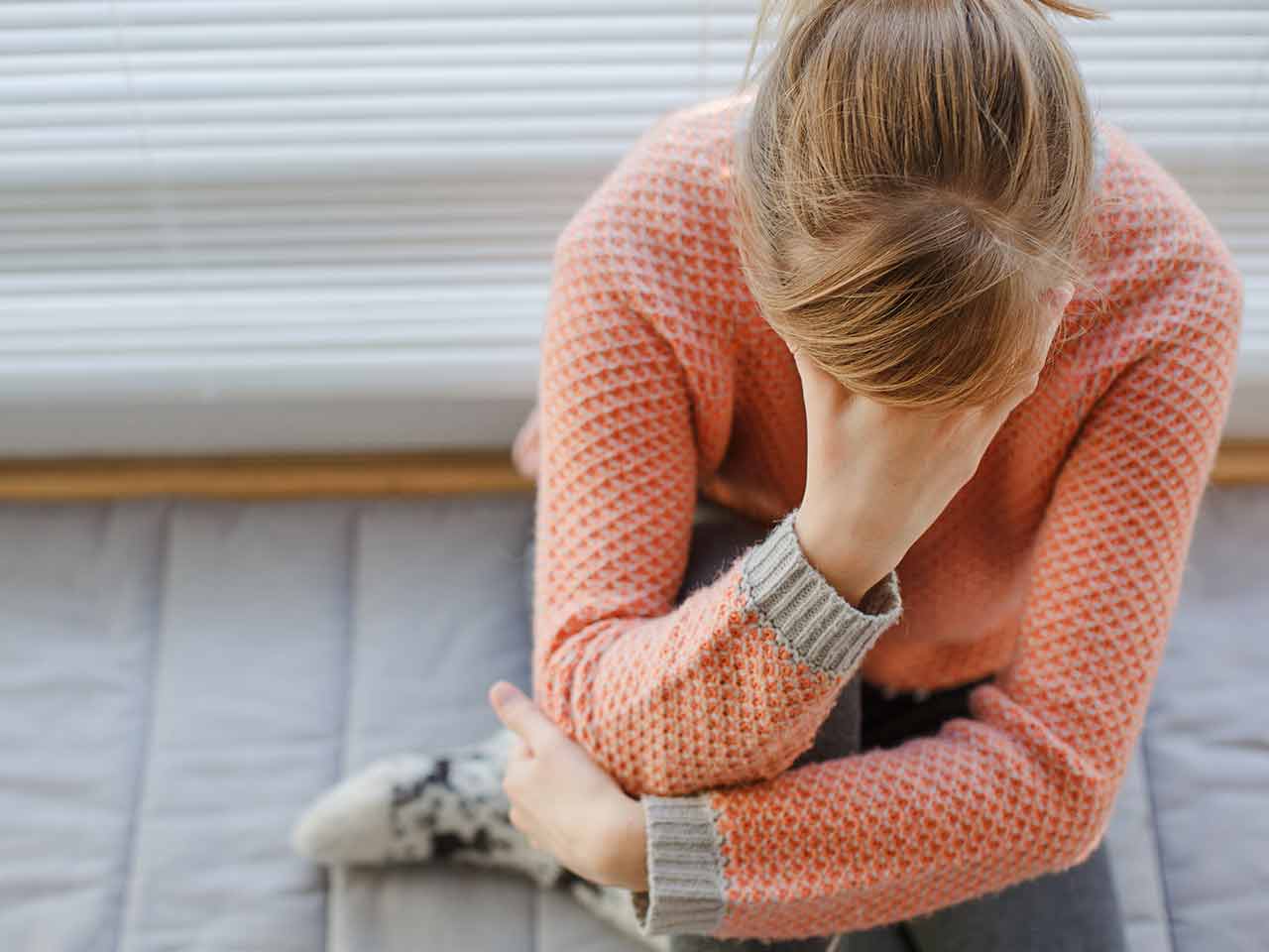 Woman sitting on the floor feeling faint 