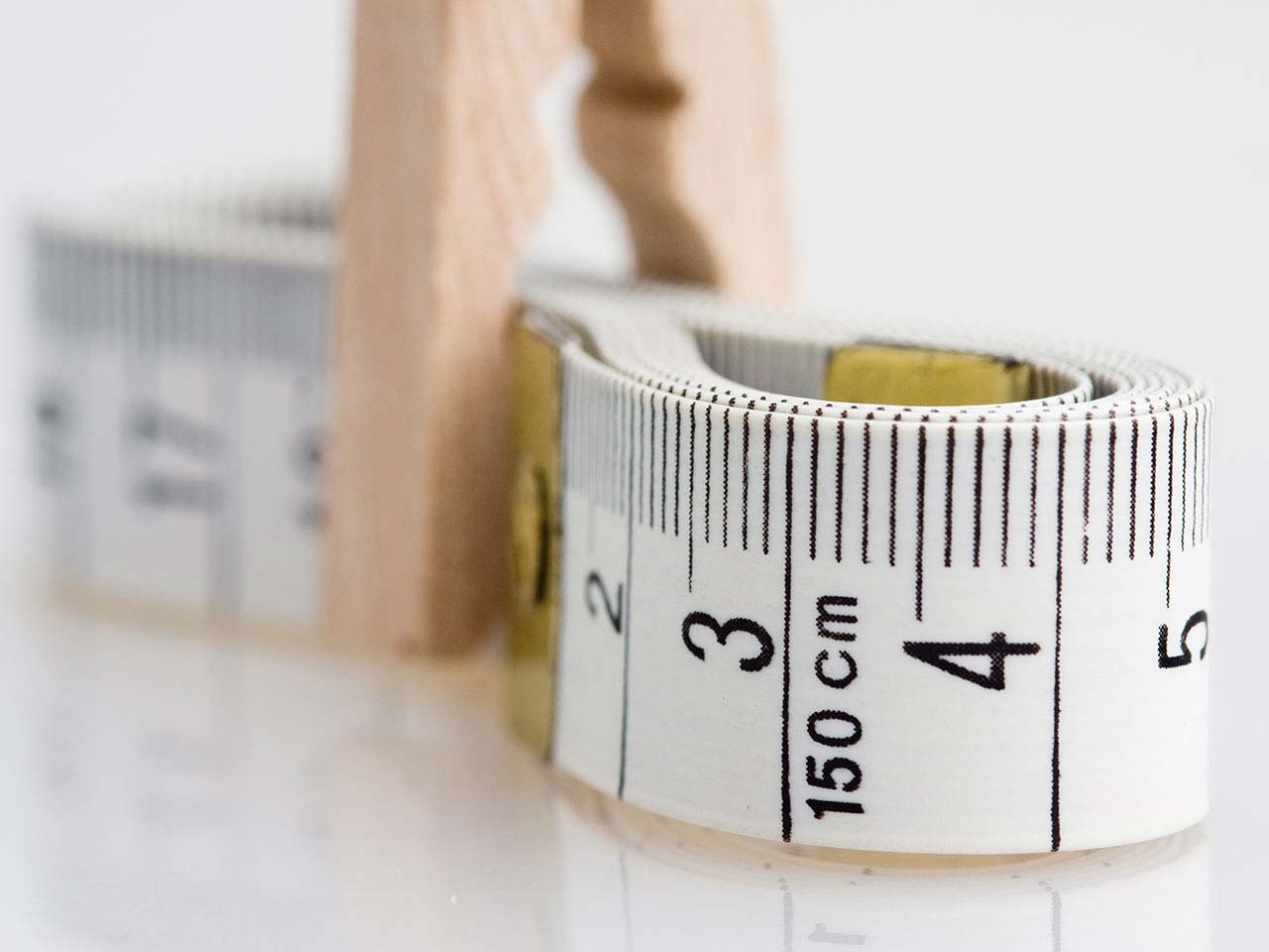 Tape measure pinched by a peg signifying fat and obesity