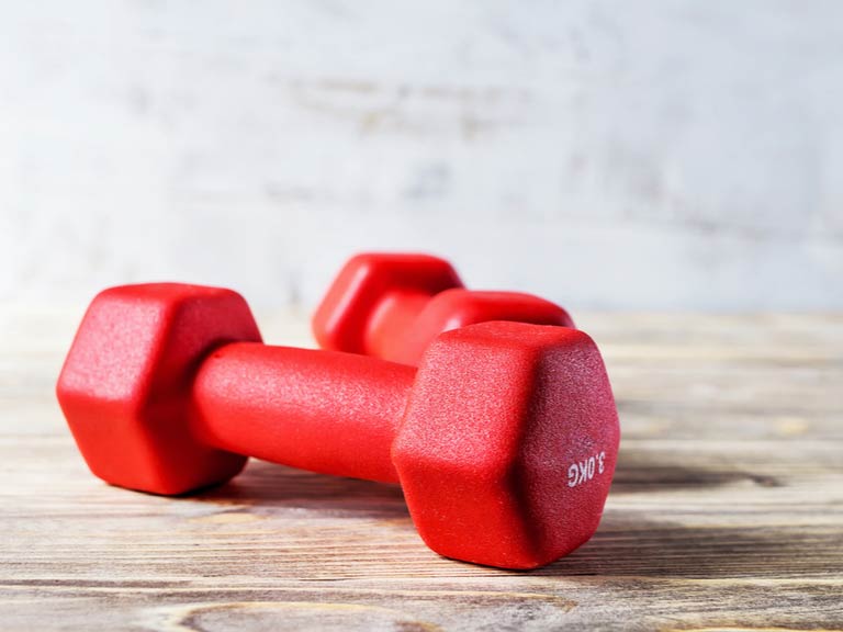 Two small dumbbells on a wooden surface