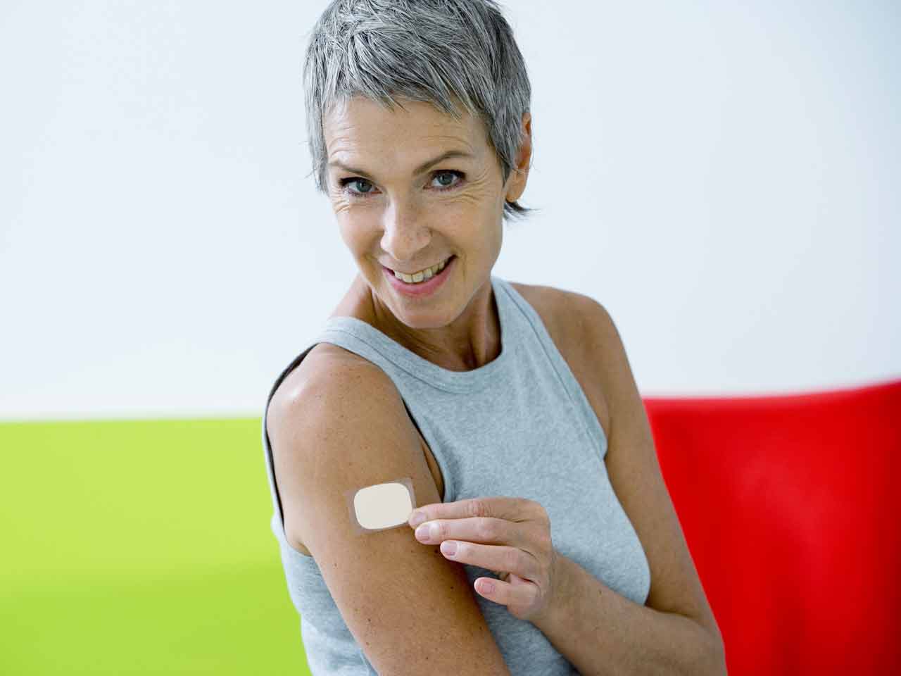Woman applying therapeutic patch