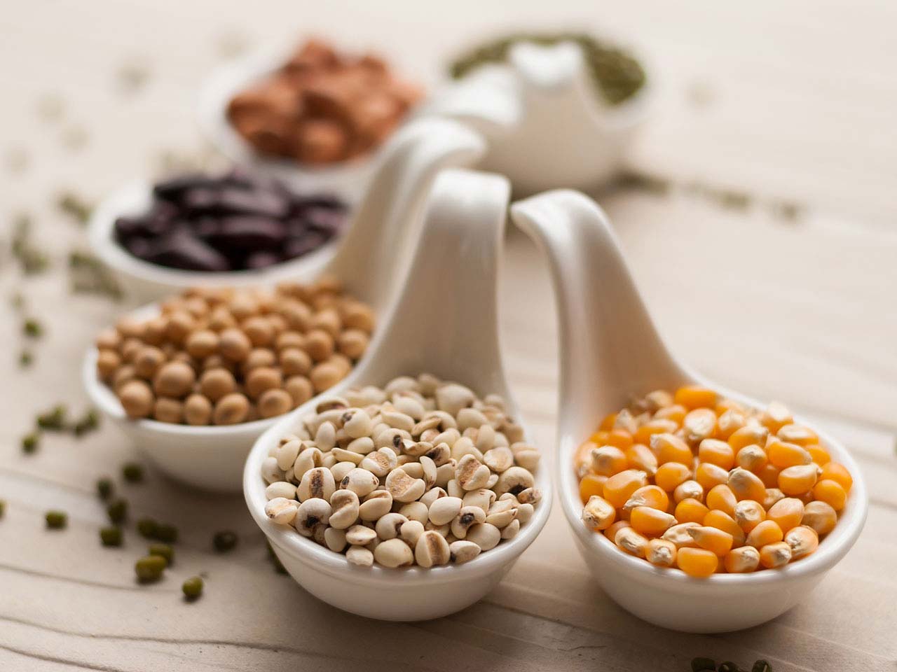 Close up of spoons containing grains and pulses