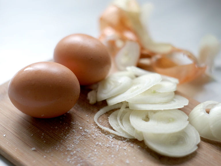 Eggs and onions on a chopping board