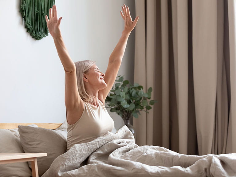 A older woman wakes up feeling refreshed and ready to face the day