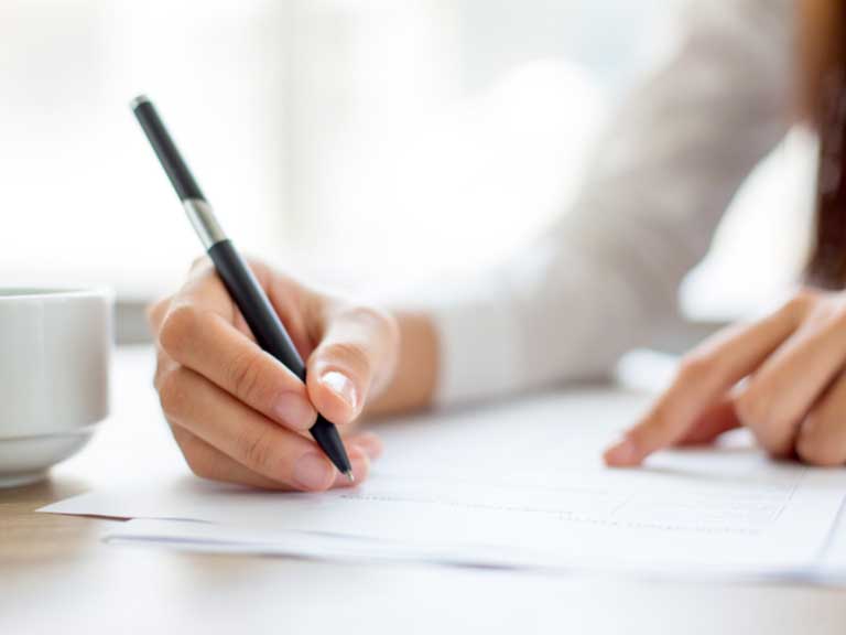 woman holding a pen and filling in a form