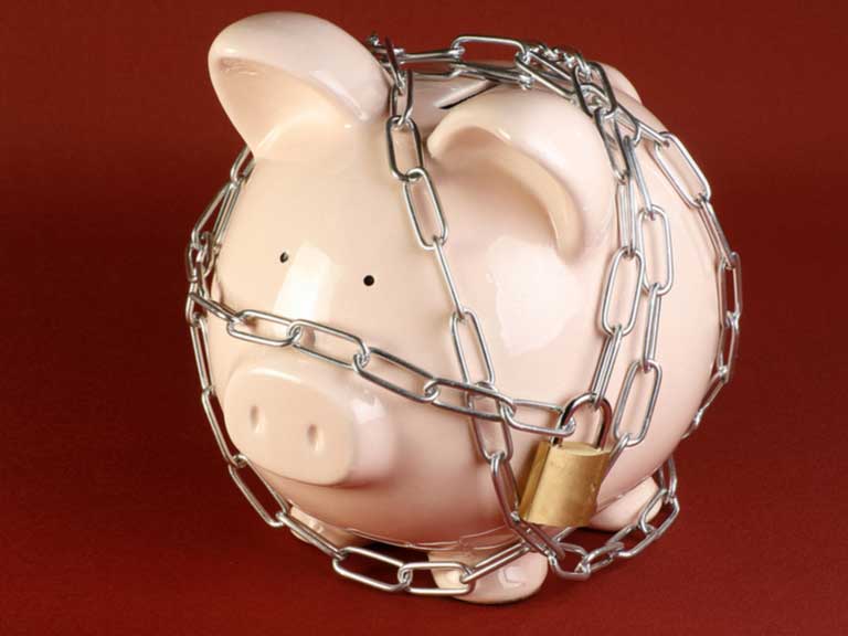 Piggy bank wrapped in a chain fastened with a padlock