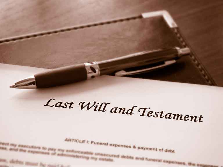 Piece of paper headed Last Will and Testament with a pen resting on the paper