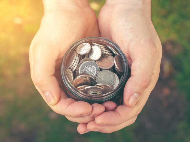 Man's hands cradling a jar of coins