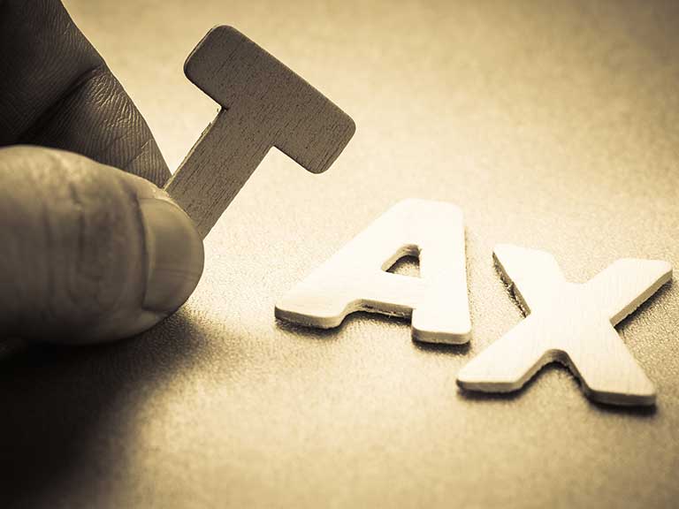 Tax spelled out in thin metal letters