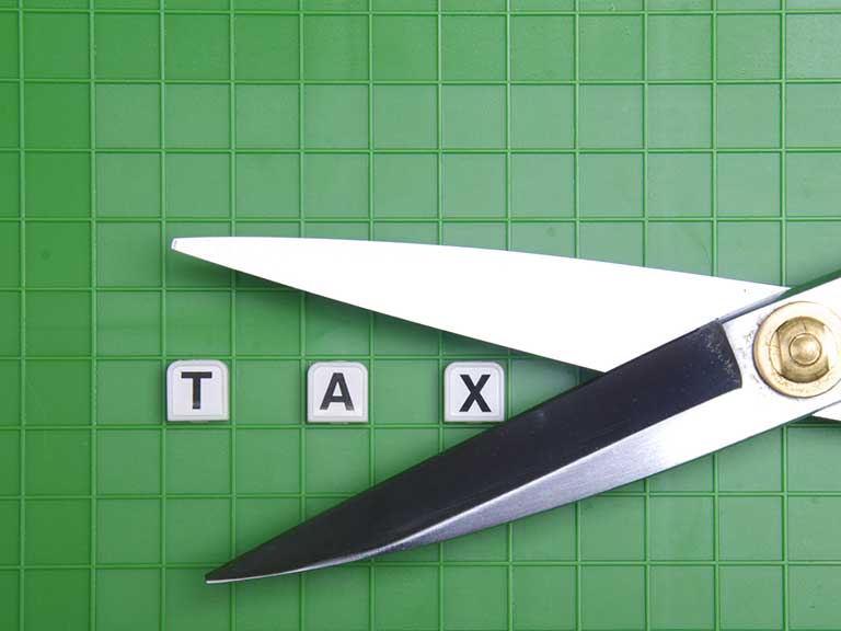 A pair of scissors snip at the word 'tax' to represent cutting a tax bill
