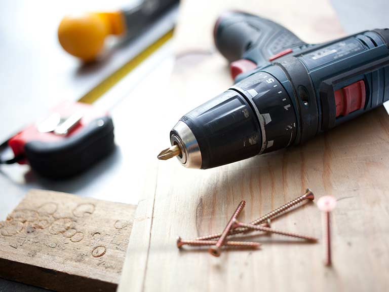 An electric drill and screws to represent DIY