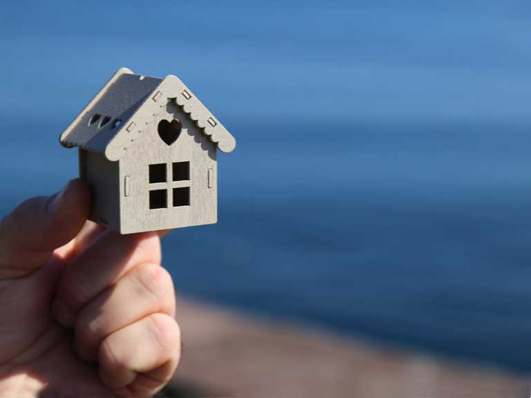 small wooden model of a house held in someone's hand