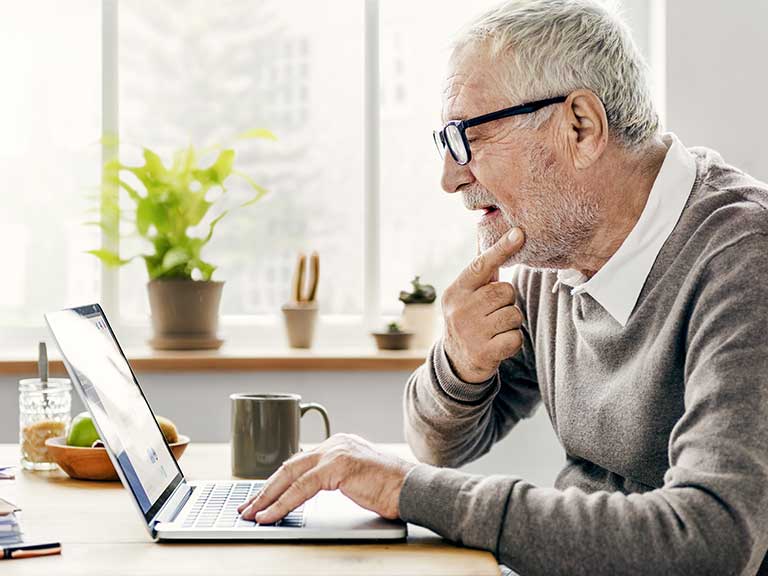 An older man looking at his computer