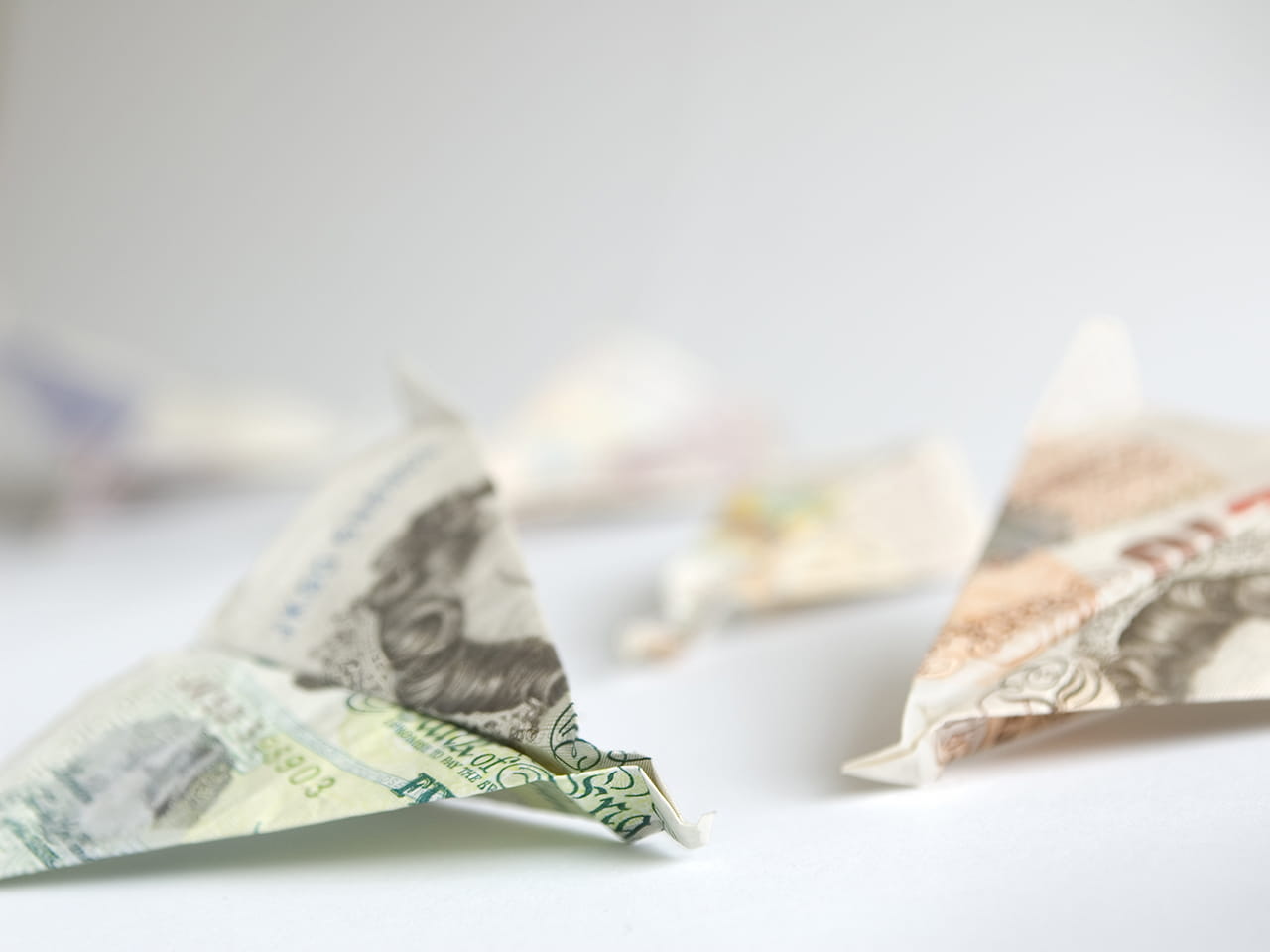 Paper aeroplanes made of bank notes to represent wasting your money or throwing it away