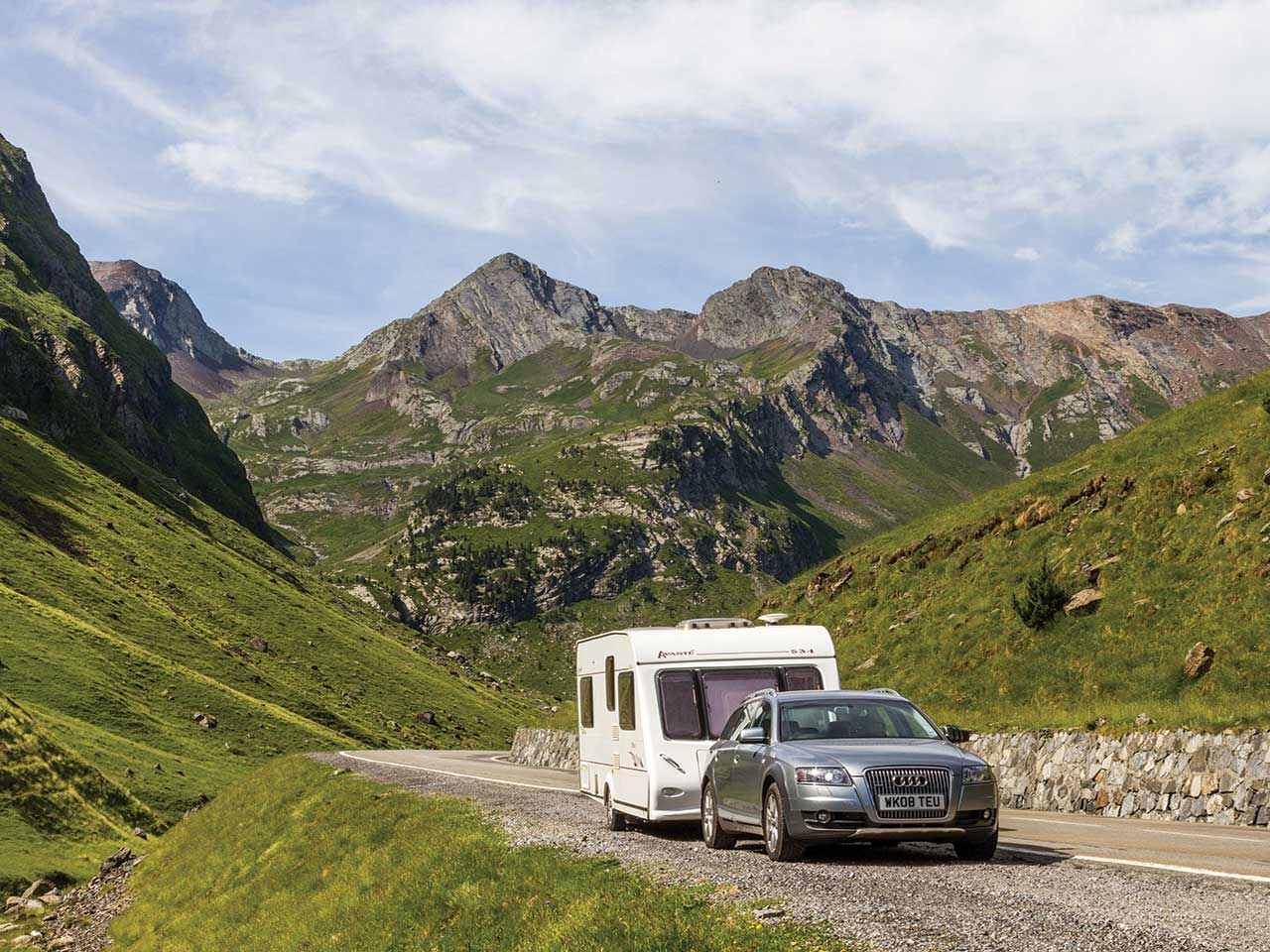 Car towing caravan through the mountains