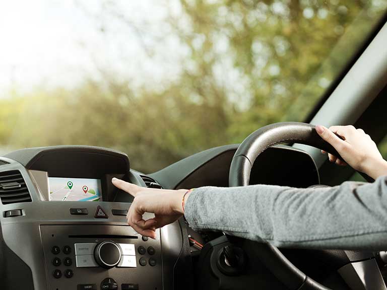 A woman uses the optional extra sat nav in her car