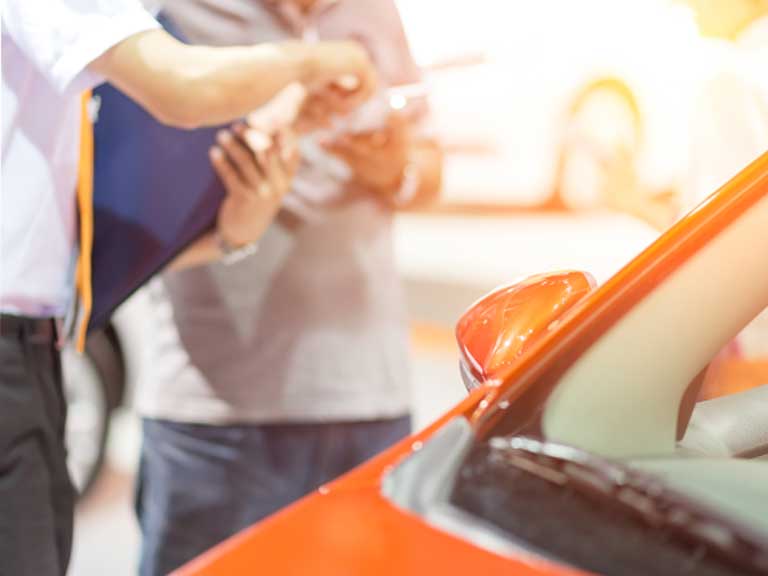 Person handing over the paperwork for a used car that they are selling