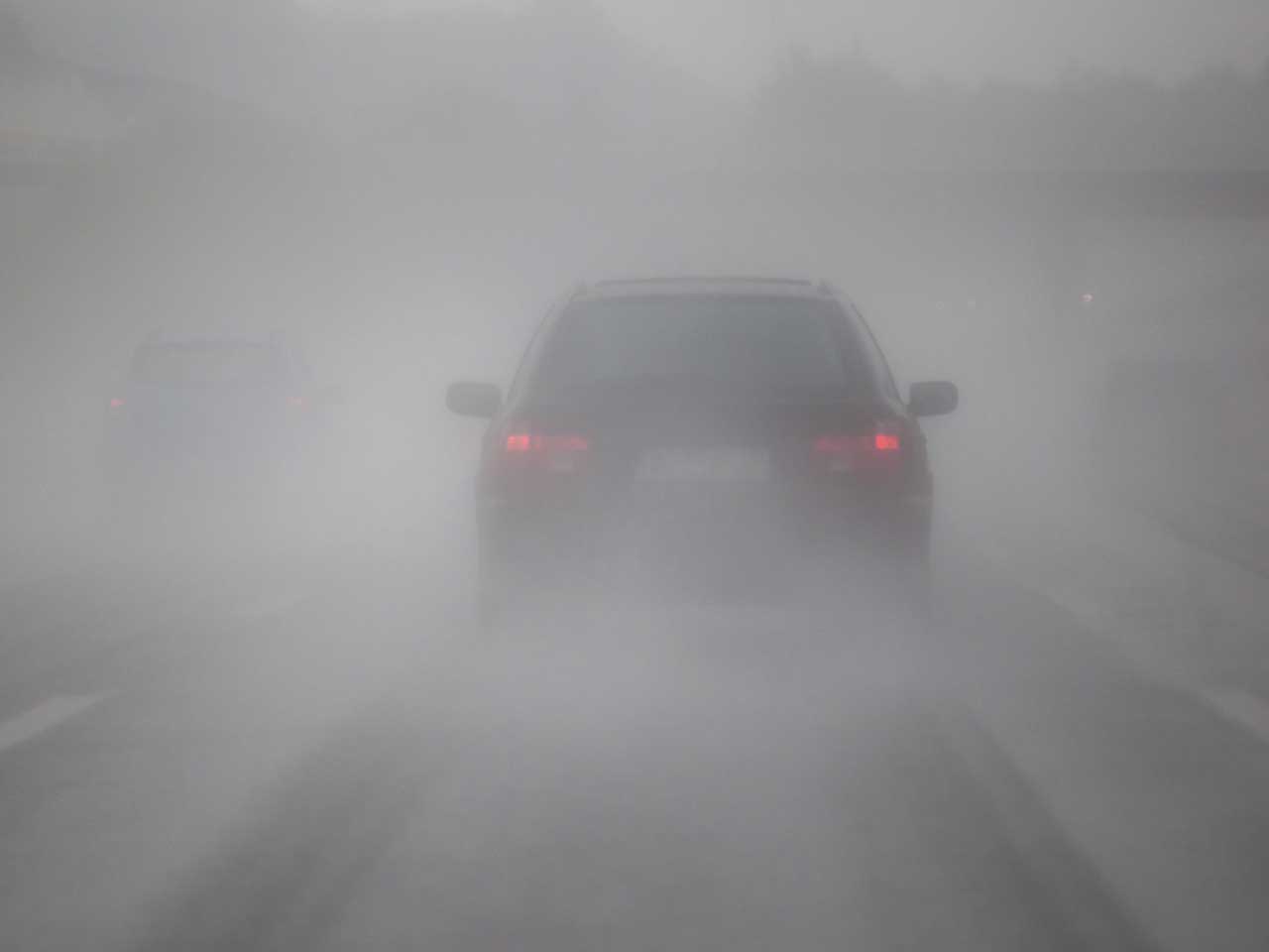 Car driving through misty and foggy road conditions
