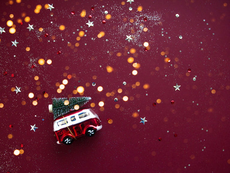 A model of a campervan on a Christmassy background to represent driving at christmas