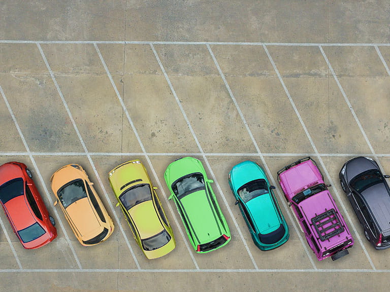 A row of cars parked in a car park to represent how wasy it is to park if you take parking lessons or invest in car parking technology 