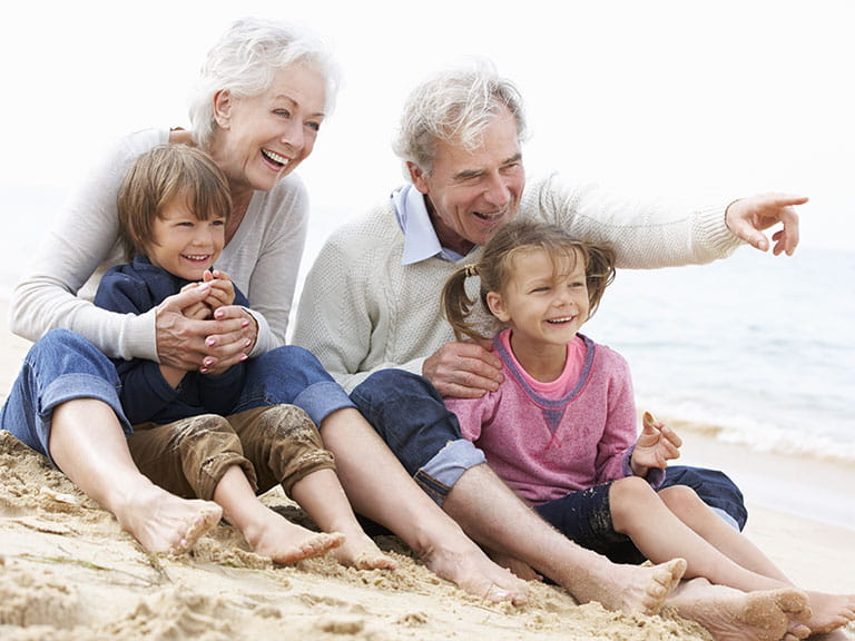 An older couple enjoy a day on the beach with two foster children