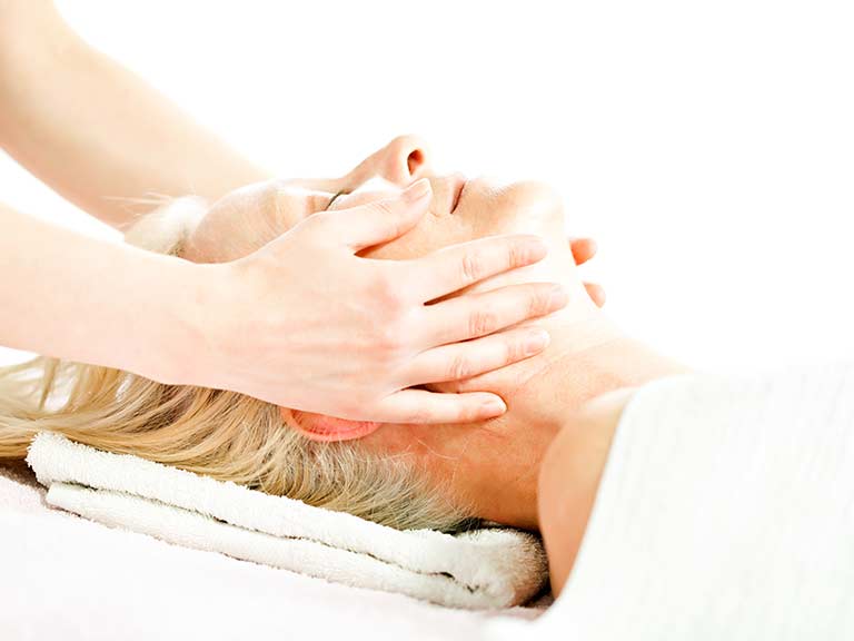 An older lady enjoys a relaxing facial massage