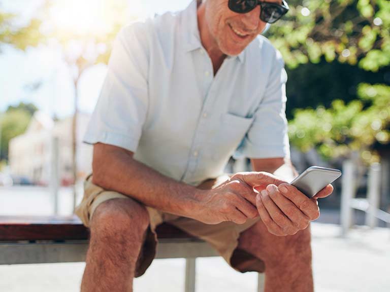 An older man enjoys the apps on his smartphone