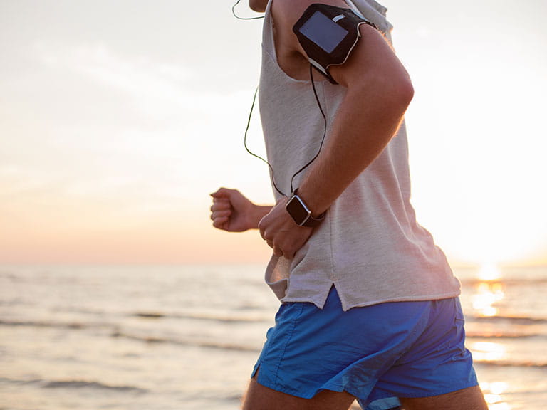 A man goes running with a phone strapped to his arm