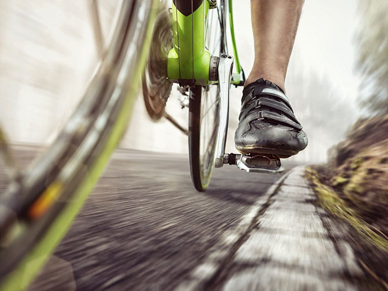 A man riding a bike wearing cycling shoes