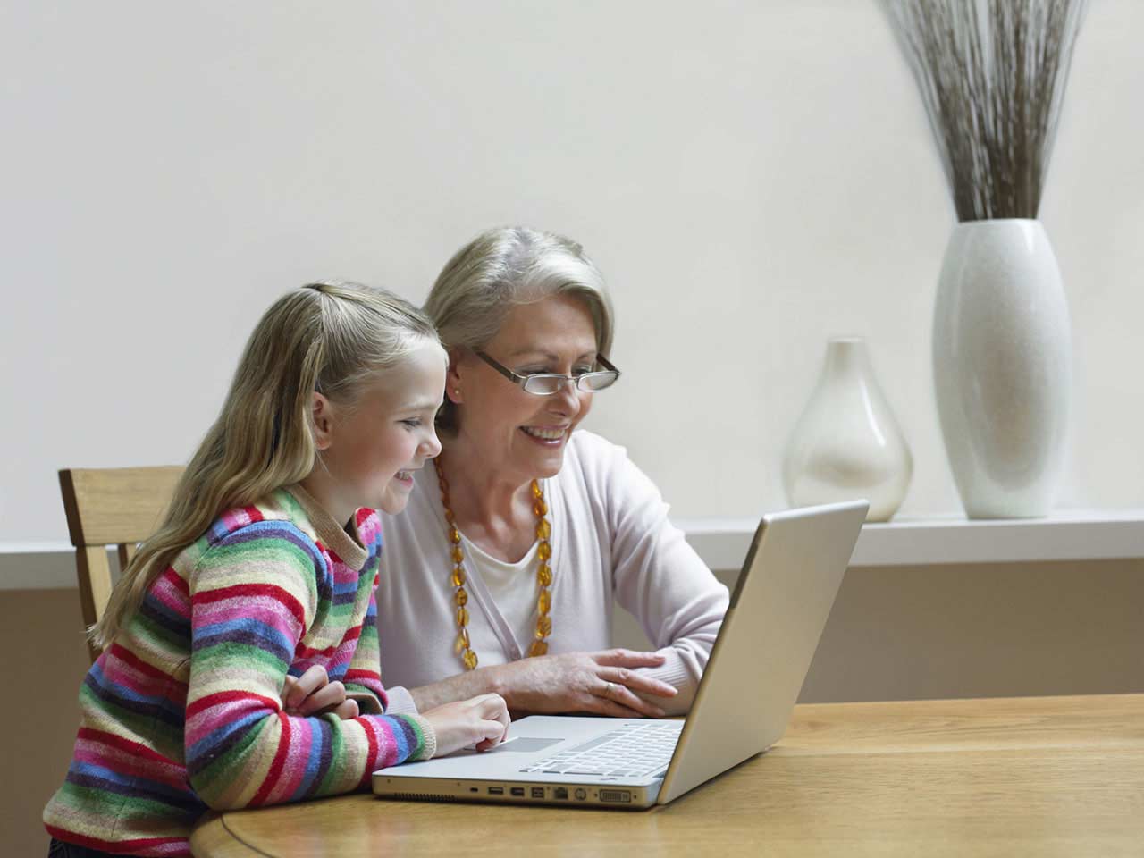 Grandma and granddaughter using laptop
