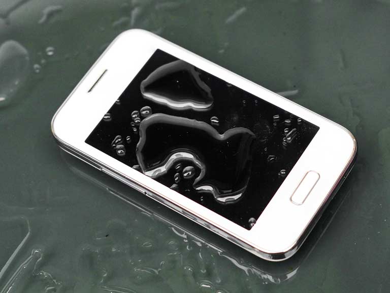 Wet mobile phone in a puddle of water