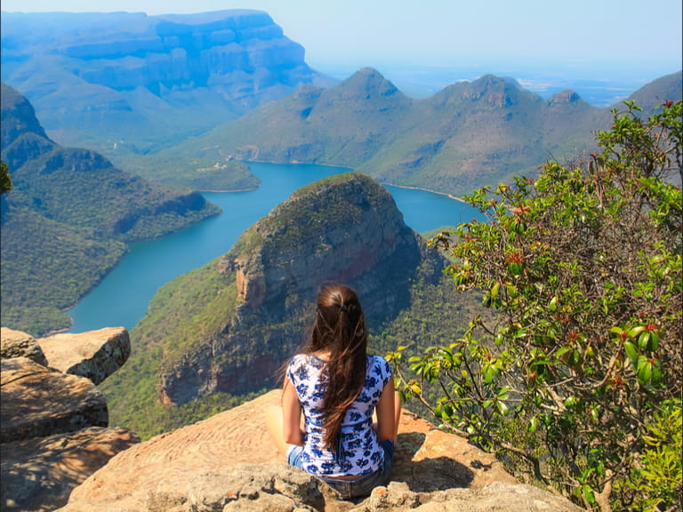 Girl sitting on stone on the cliff in the Blyde River Canyon, South Africa