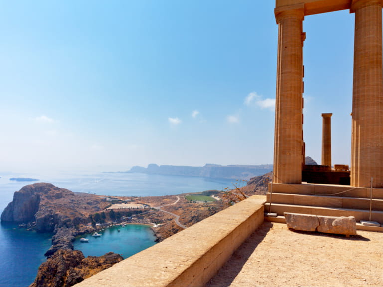 Acropolis of Lindos. Doric columns of the ancient Temple of Athena Lindia the IV century BC and the bay of St. Paul. Greece. Rhodes