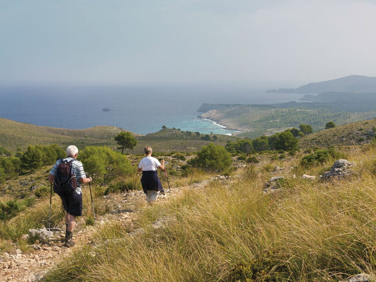 Older couple walking along the Cami de Cavalls, Menorca