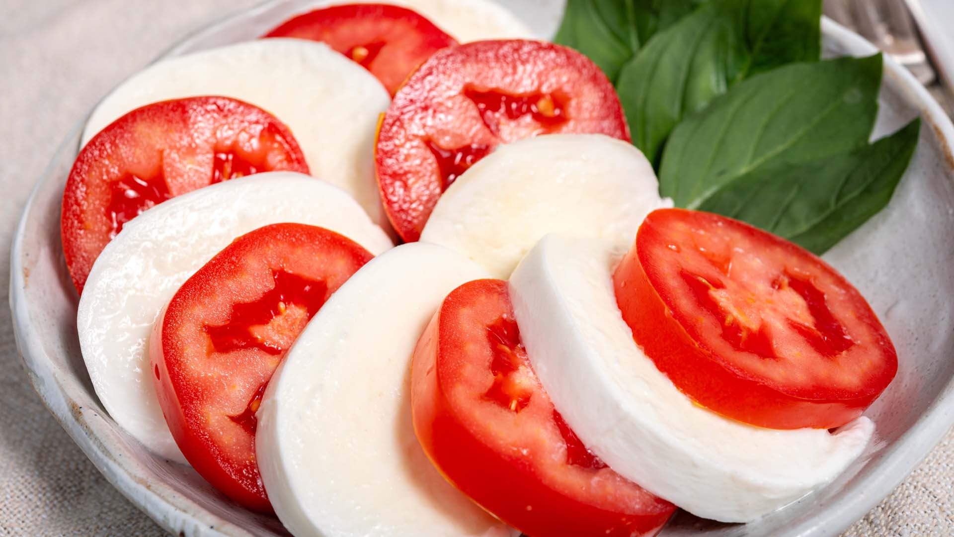 Slices of tomato and mozzarella arranged on a plate