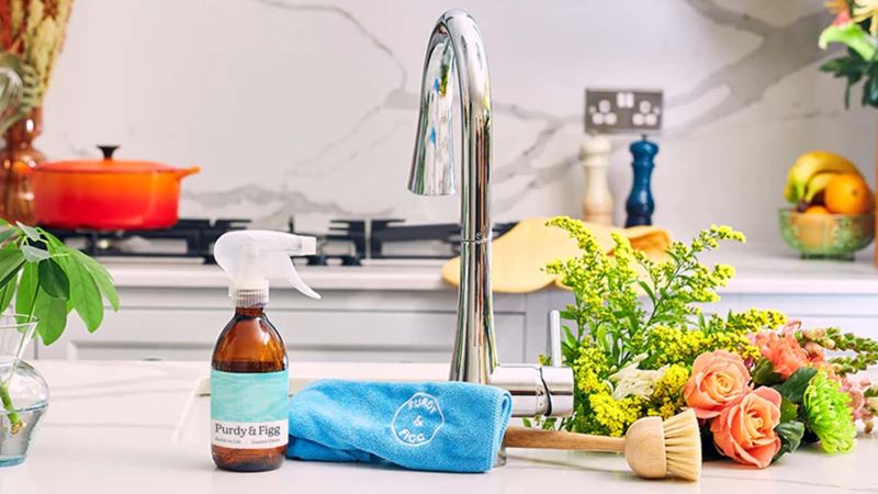 A kitchen island with a sink and tap, eco-friendly hand soap and a bouquet of flowers