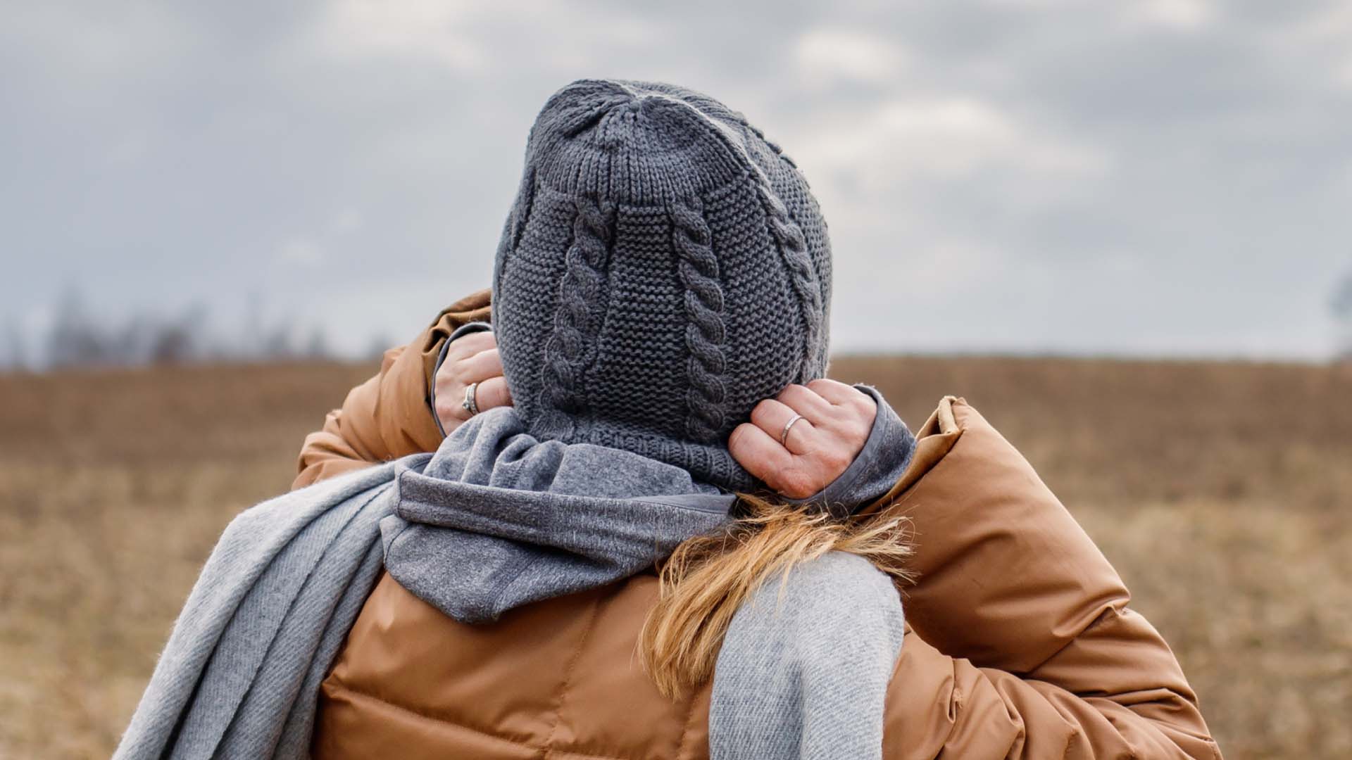 person pulling their hat on