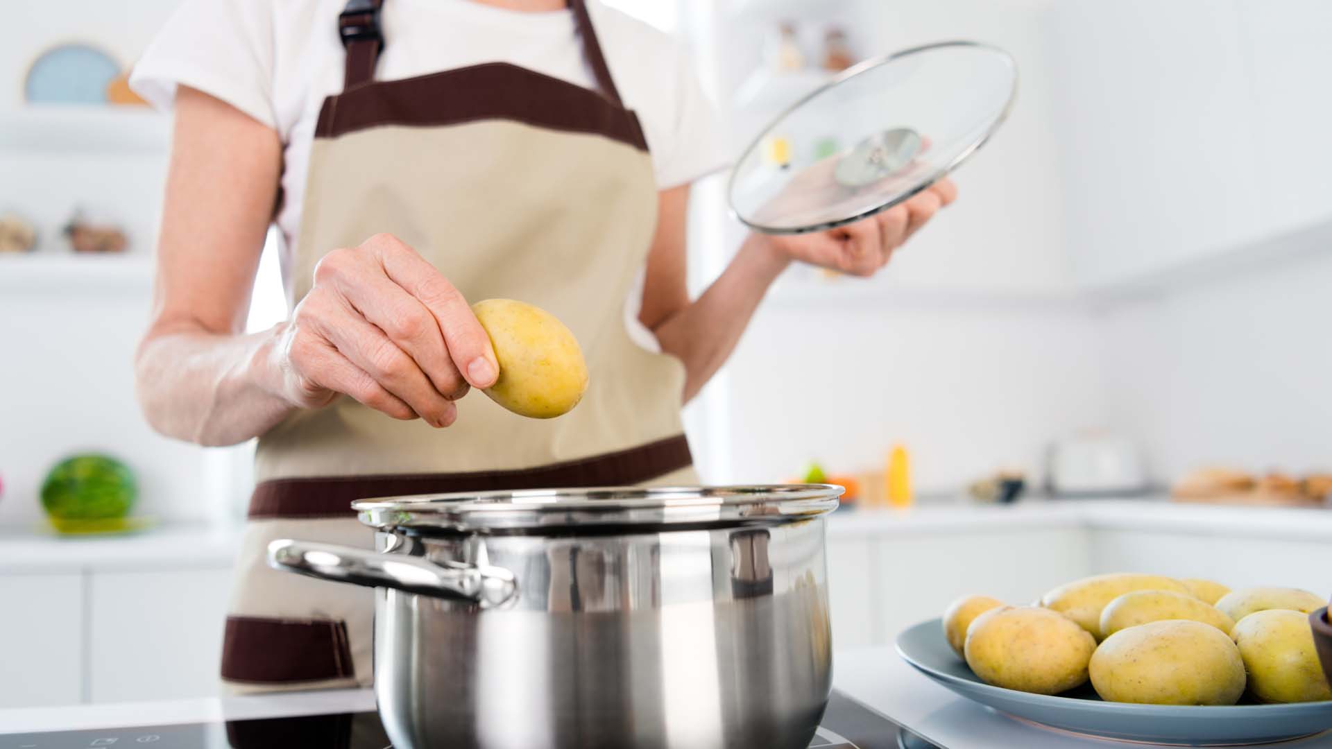 Cropped photo of lady cook potatoes wear apron white t-shirt at kitchen alone