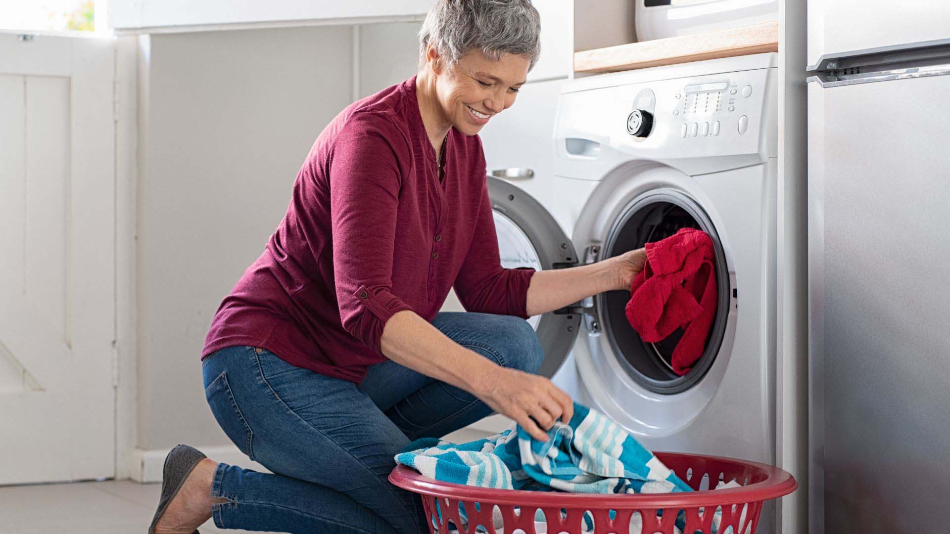 woman putting washing in the washing machine 