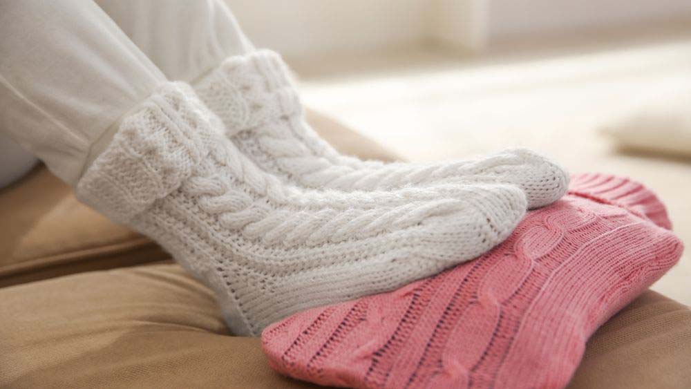 Feet in cosy socks on a wool covered hot water bottle