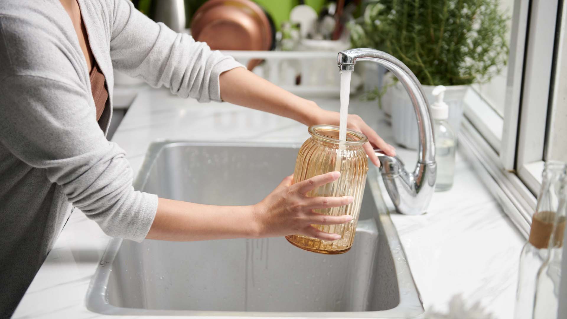 Woman filling vase with tap water