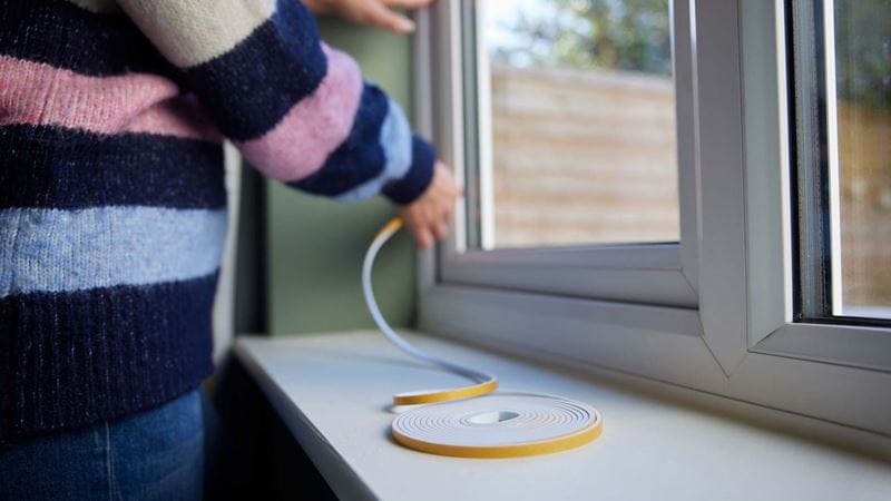 A woman insulating a window