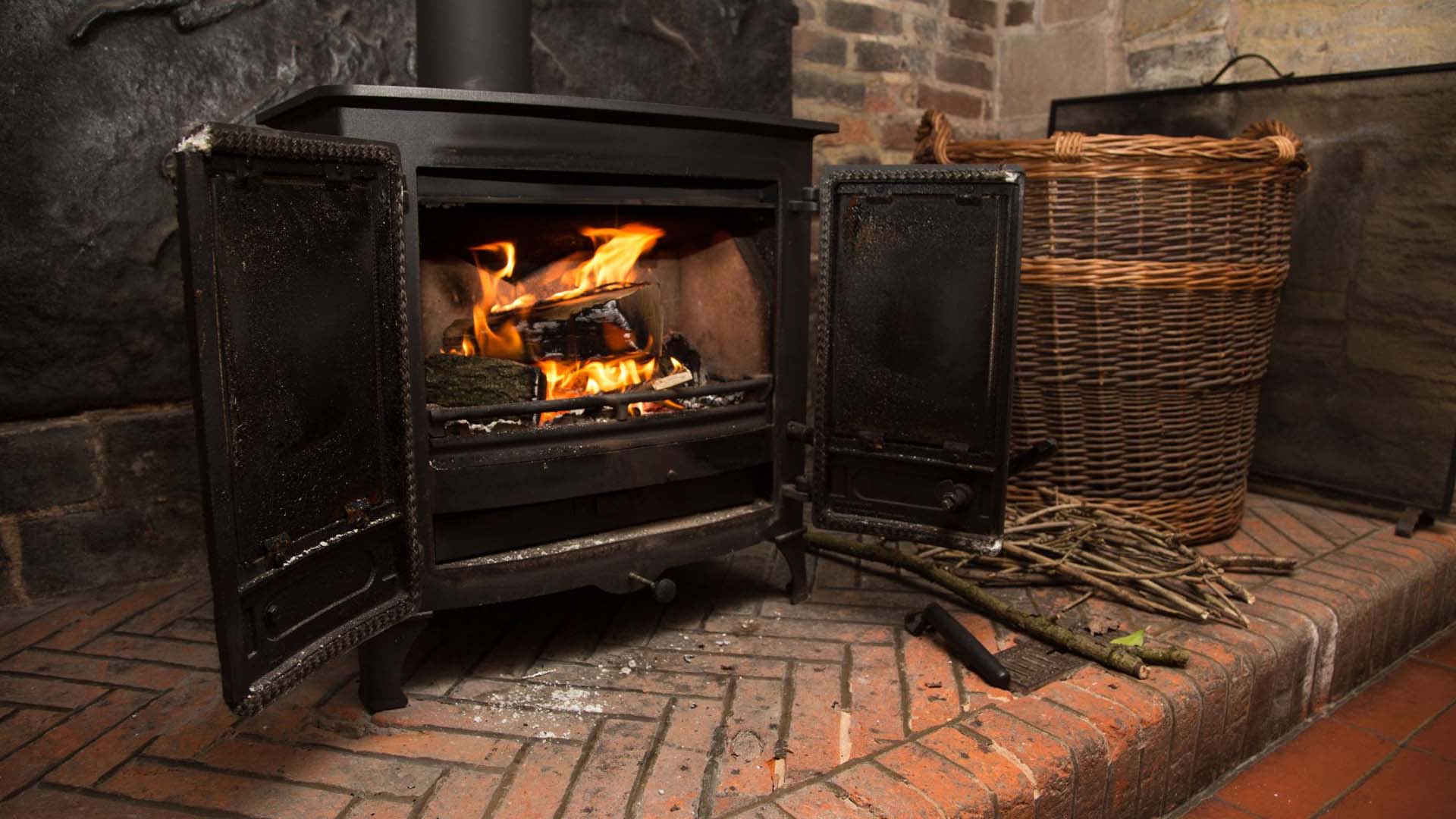A large wood burner with a fire burning inside